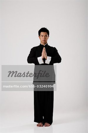 Man meditating wearing traditional Chinese clothes