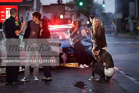 Jeunes et policier sur les lieux de l'accident de voiture