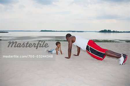 Father and Son Doing Push-ups on the Beach