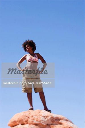 Frau, stehend auf einem Felsen gegen Himmel