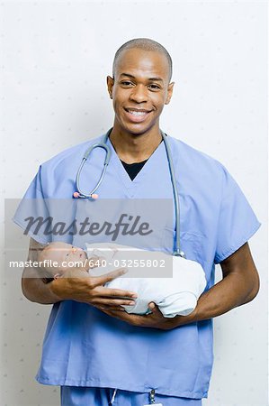 Male Doctor holding newborn baby