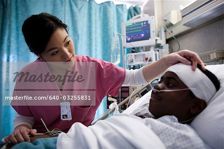 Infirmière de parler avec le garçon dans son lit d'hôpital