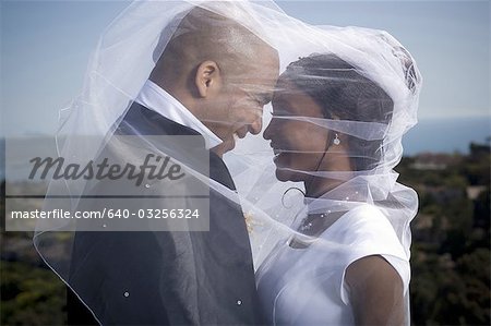 Profil von einem jungen Brautpaar unter einem Schleier
