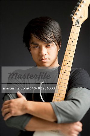 Young man holding guitar, portrait