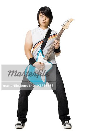 Jeune homme jouer de la guitare électrique, studio shot