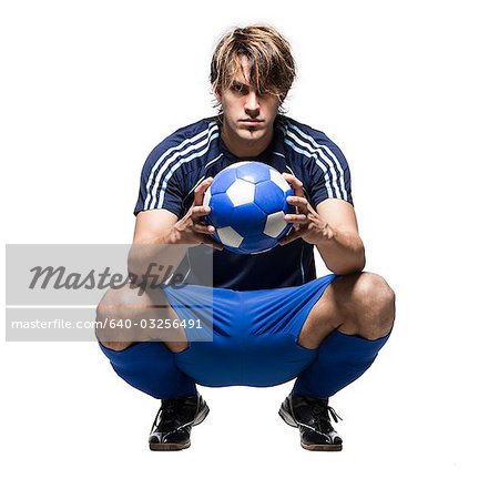 Portrait en studio de joueur de football tient ballon