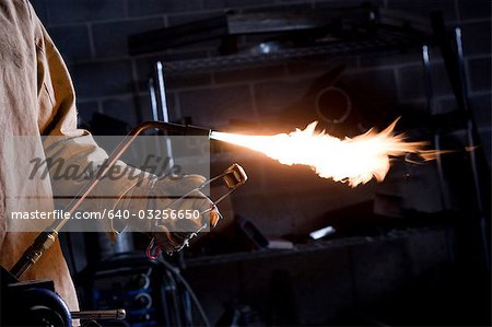 USA, Utah, Orem, male welder with blowtorch in workshop