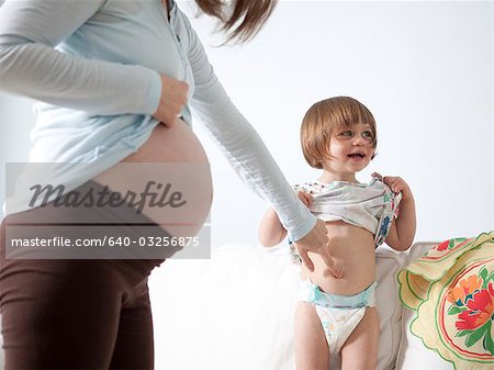 USA, California, San Francisco, girl (2-3) with mother touching her belly