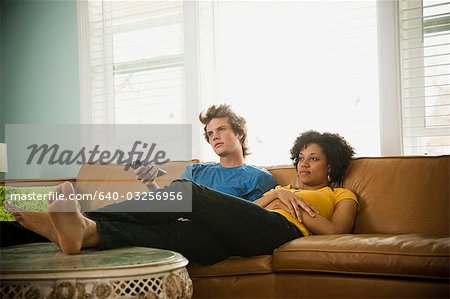 USA, Utah, Provo, couple sitting on sofa watching TV