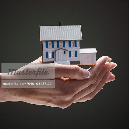 Toy house in young woman's hands