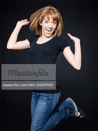 Young cheerful woman jumping, studio shot