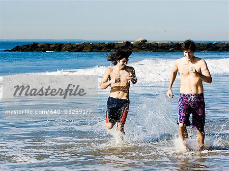 Deux hommes en cours d'exécution sur la plage