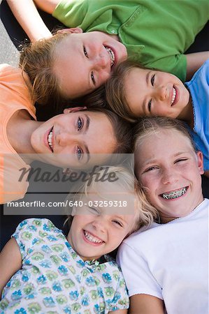 Group of girl friends lying on their backs smiling