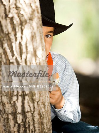 Garçon en costume de cowboy avec arme-jouet