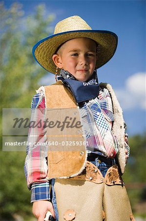Boy in cowboy costume outside