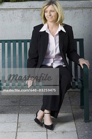 Geschäftsfrau, die auf einer Bank sitzen