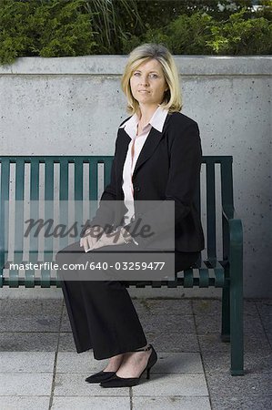 Femme d'affaires assis sur un banc