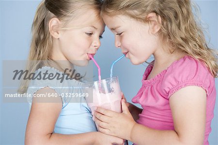 Zwei Mädchen teilen ein Milchshake