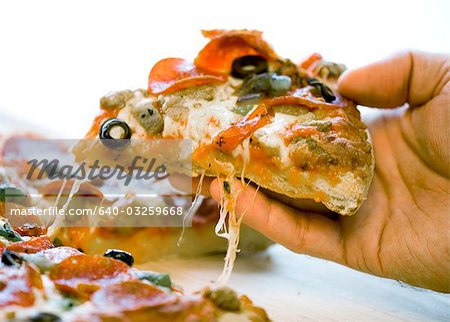 Hand slicing pizza