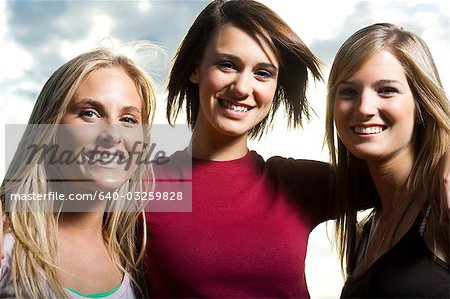 Trois amies adolescentes souriant
