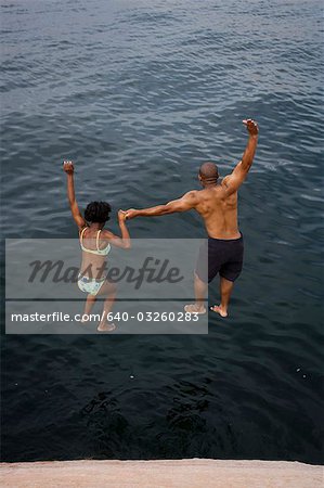 Couple jumping into water