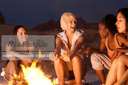 Femmes cuisson guimauves sur le feu de camp