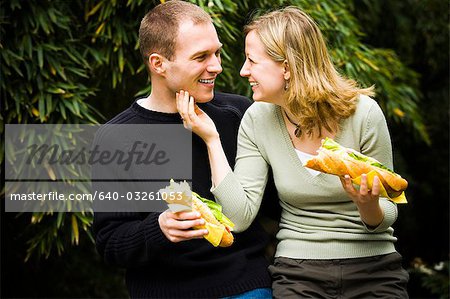 Closeup of couple holding sandwiches