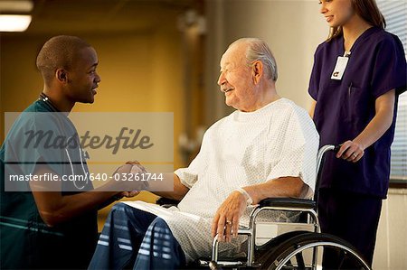 Mature man in wheelchair with doctor and nurse