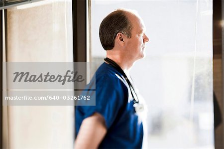 Male doctor looking through window