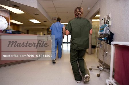 Doctor and nurse running in corridor from behind