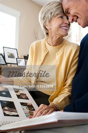 Rear view of mature couple with photo album