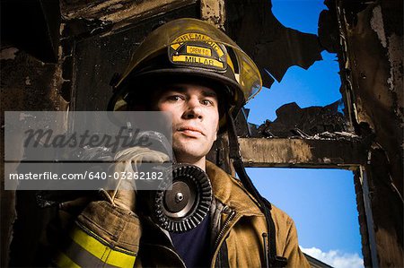 Portrait d'un pompier avec lance d'incendie