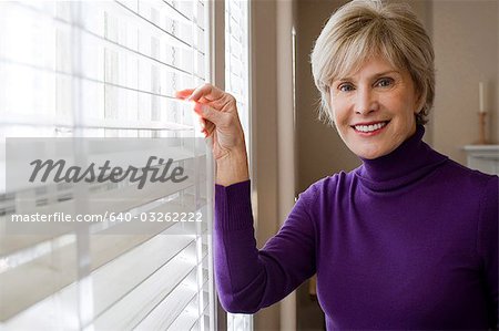 Mature femme regardant par la fenêtre
