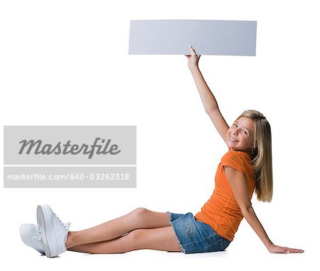 Girl holding blank sign sitting and smiling