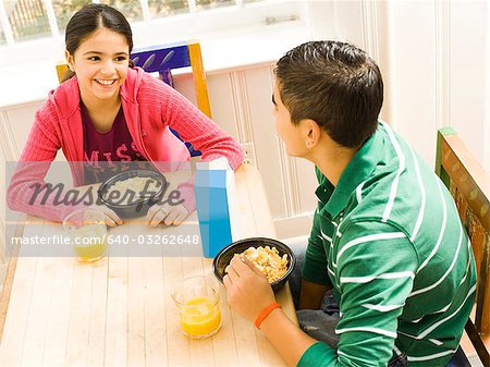 Girl sticking tongue out at breakfast table