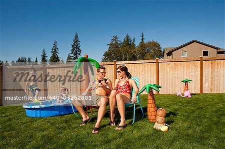 Family in yard with children's pool and cocktails