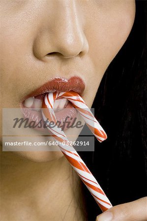 Closeup, Frau mit rotem Lippenstift Essen Zuckerstange