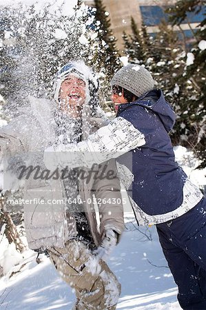 Young adults play fighting in the snow