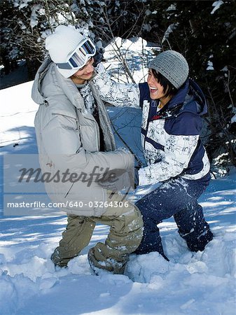 Young adults play fighting in the snow