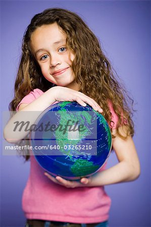 Jeune fille se penchant sur un globe terrestre