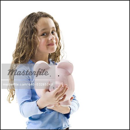 Young girl hugging piggy bank