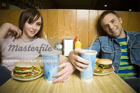 Portrait d'un jeune homme et une jeune adolescente, assis dans un restaurant