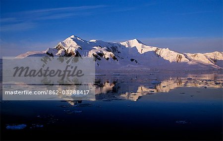 Sunrise and mirror reflection of Adelaide Island.