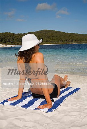 Ein Lounger sitzt wieder auf den weißen Sandstrand von Lake McKenzie auf Fraser Island.