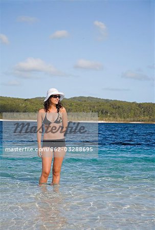 Eine Frau einen Blick auf die klaren Wasser und weißem Sand der Lake Mckenzie auf Fraser Island.