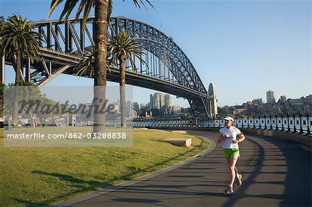 Ein Jogger am frühen Morgen rundet Daves Point Reserve am Fuße der Harbour Bridge in Sydney Cove