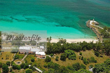Aerial view of Little Whale House with the beach and lighthouse behind Little Whale Cay