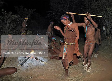 Un homme et une femme d'une communauté San dansent pendant chanter autour de leur feu de camp. Les hommes ont des hochets enroulés autour de leurs jambes pour aider le reste d'entre eux de garder le rythme au cours de leurs danses.Ces chasseurs-cueilleurs NS vivent dans les collines de Xai Xai à proximité de la frontière namibienne. Leur mode de vie traditionnel est en train de disparaître rapidement.