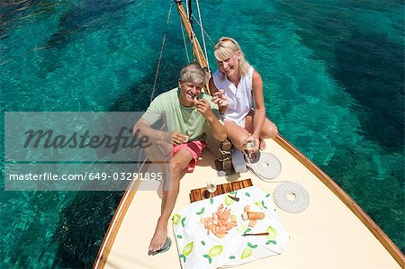 A senior couple picnic while sailing