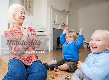A grandmother playing with two toddlers